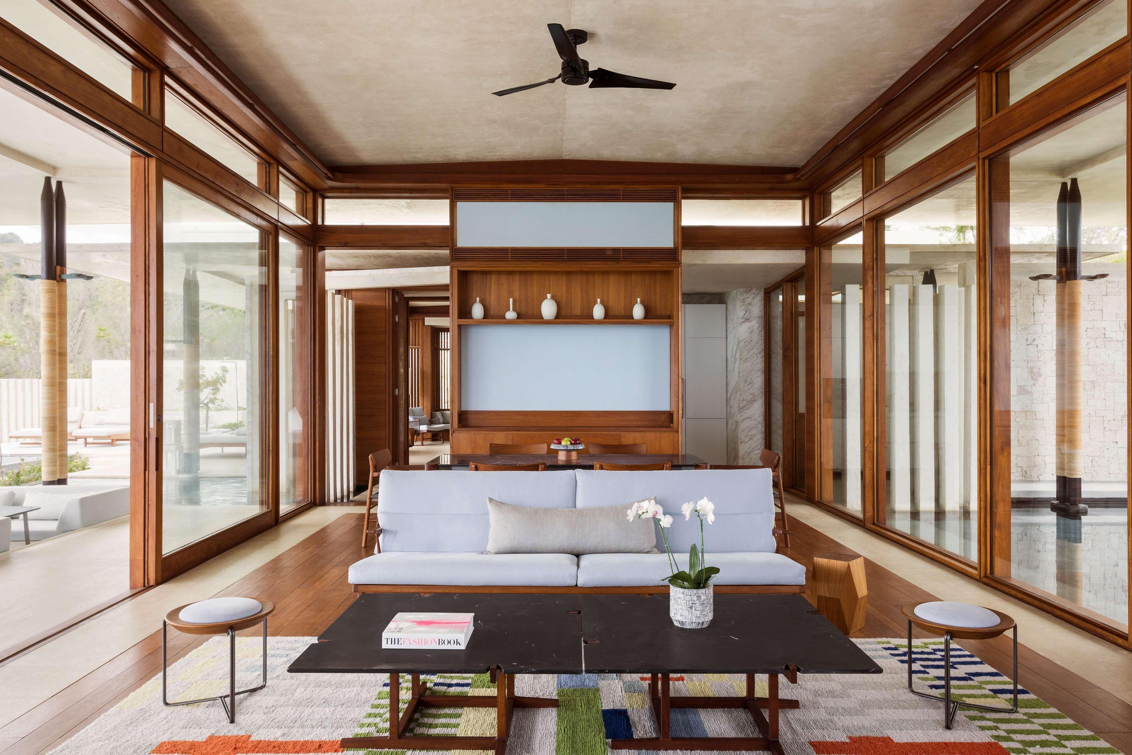 Amanera — living pavilion framed by floor-to-ceiling glass and bilateral water views