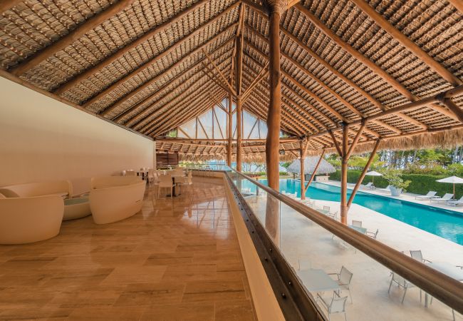 Portillo Beach Club — interior under the thatched roof, looking onto the pool
